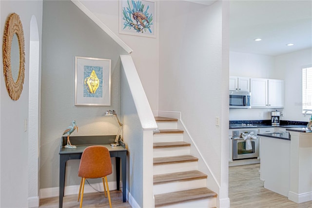 staircase featuring sink and hardwood / wood-style floors