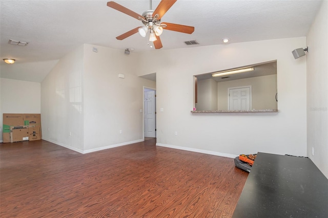 empty room with ceiling fan, lofted ceiling, and dark hardwood / wood-style floors