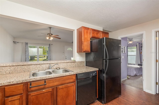 kitchen featuring sink, dark wood-type flooring, ceiling fan, black appliances, and a textured ceiling