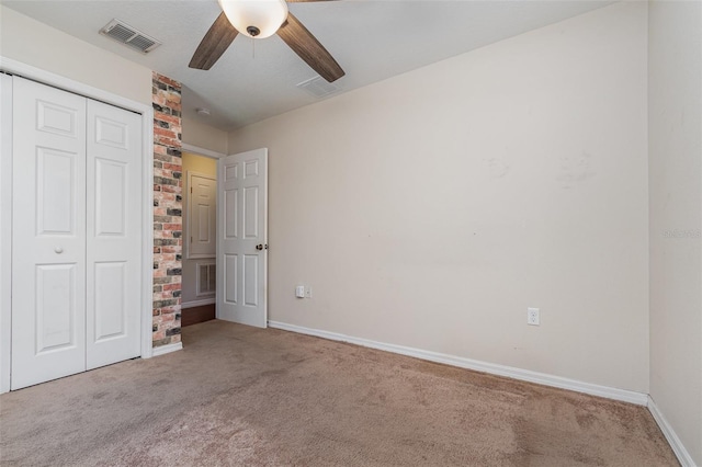 unfurnished bedroom with ceiling fan, a closet, and light carpet