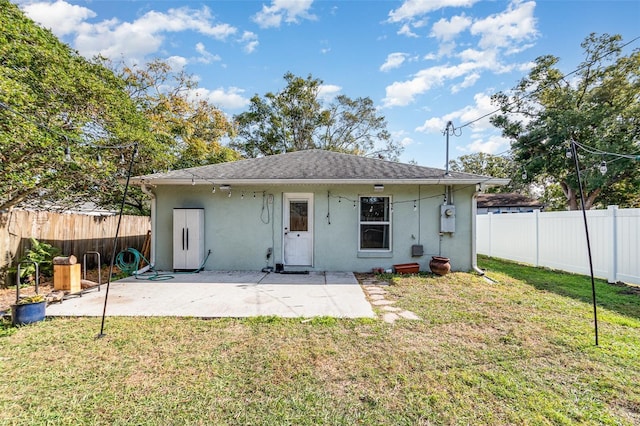 rear view of house featuring a lawn and a patio