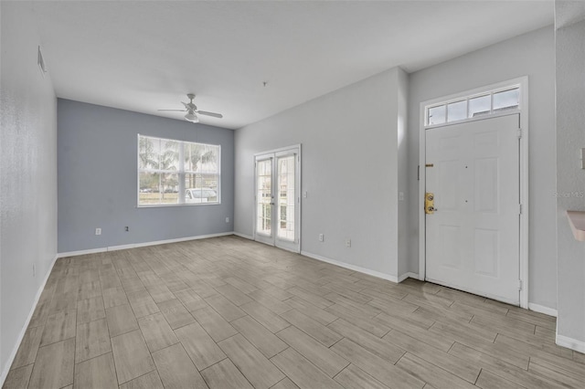 foyer entrance with ceiling fan and light wood-type flooring