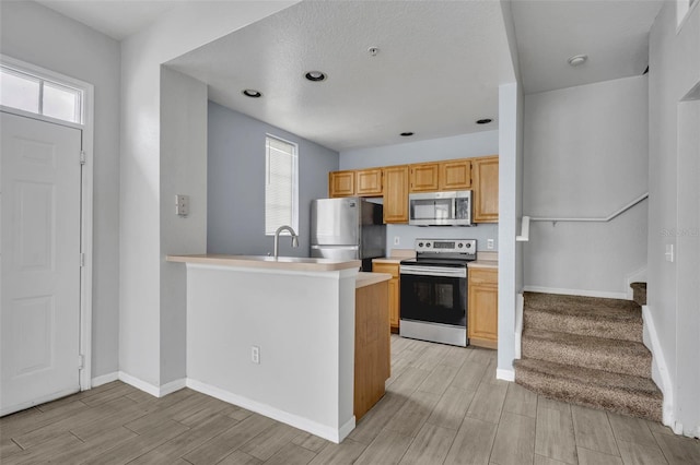 kitchen with sink, plenty of natural light, stainless steel appliances, and kitchen peninsula