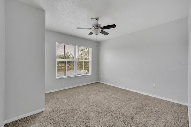 carpeted empty room featuring a textured ceiling and ceiling fan