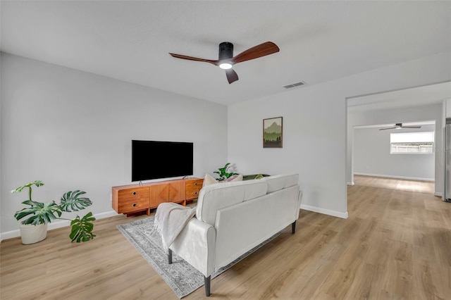 living room with ceiling fan and light wood-type flooring