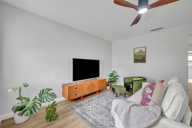 living room with light hardwood / wood-style flooring and ceiling fan