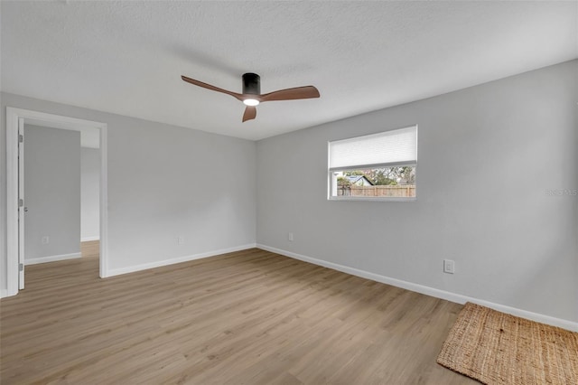 empty room featuring ceiling fan, a textured ceiling, and light wood-type flooring