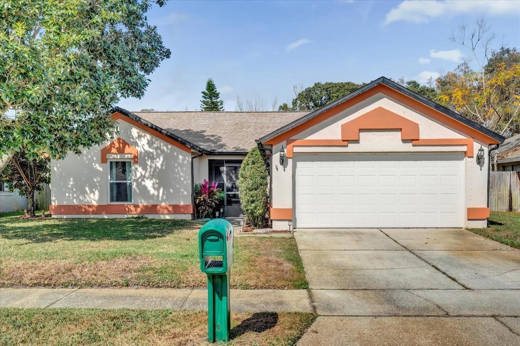 single story home featuring a garage and a front lawn