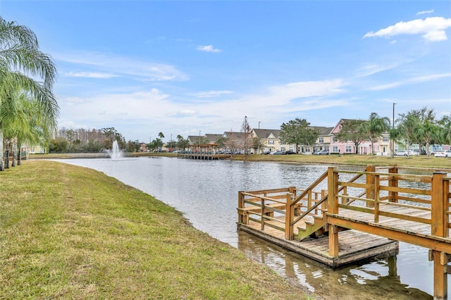 dock area with a yard and a water view