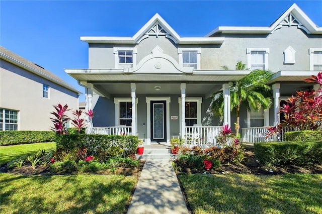 view of front of property with a porch and a front lawn