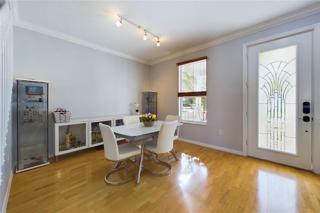 dining space featuring ornamental molding and light hardwood / wood-style flooring