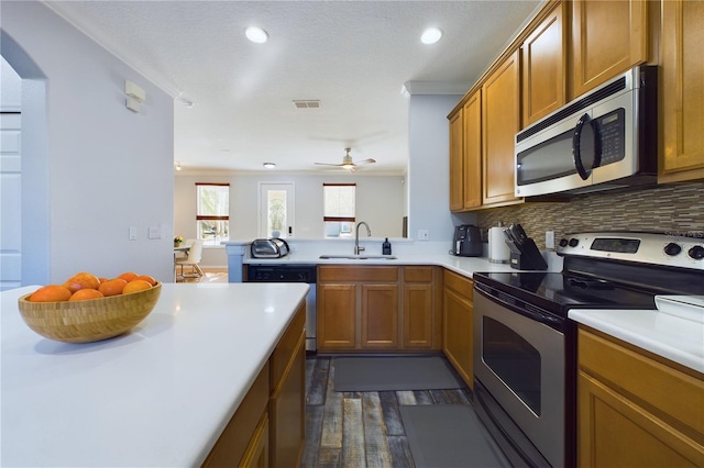 kitchen with tasteful backsplash, sink, dark hardwood / wood-style flooring, kitchen peninsula, and stainless steel appliances