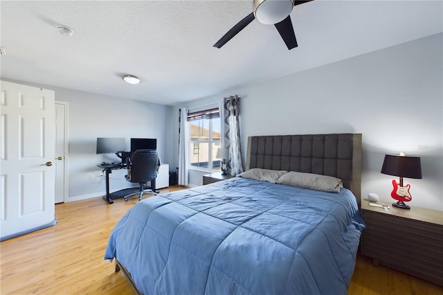 bedroom featuring a textured ceiling, ceiling fan, and light wood-type flooring