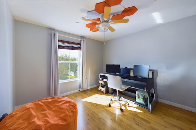 home office with ceiling fan and light hardwood / wood-style flooring