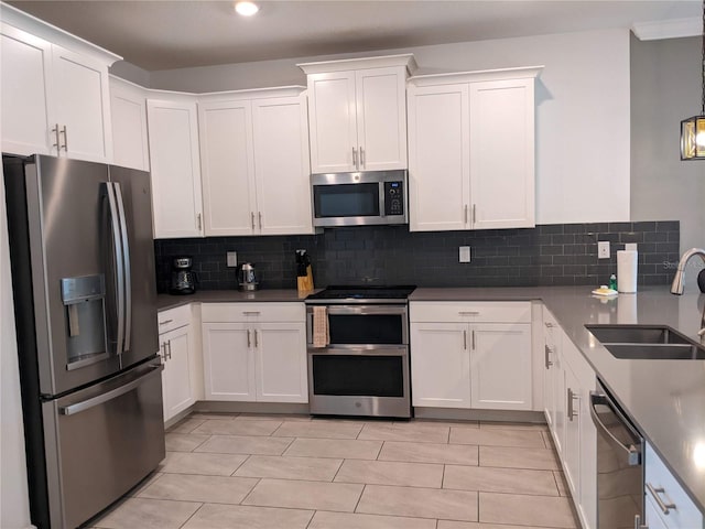 kitchen with stainless steel appliances, white cabinetry, sink, and decorative backsplash