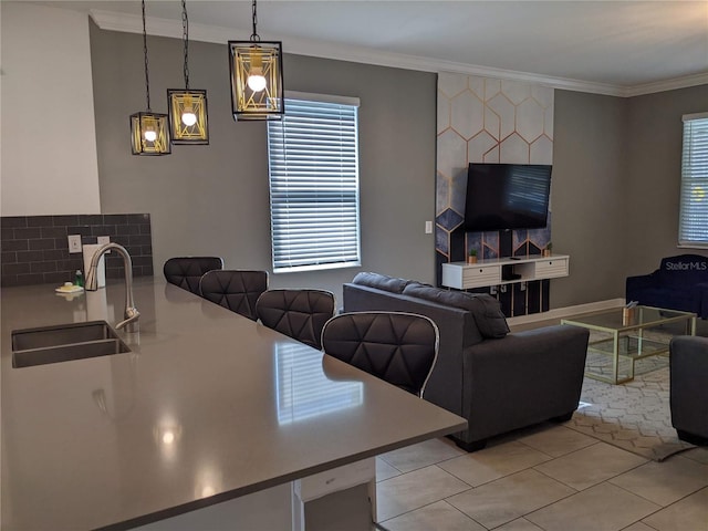 living room featuring crown molding, sink, and light tile patterned floors