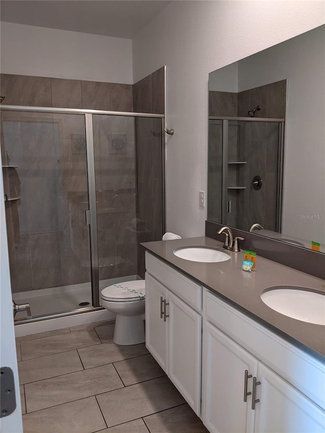 bathroom with vanity, a shower with shower door, and toilet