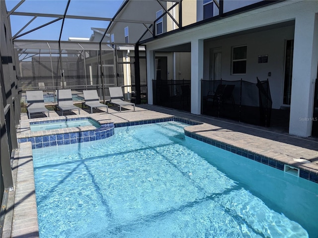 view of swimming pool featuring an in ground hot tub, a lanai, and a patio