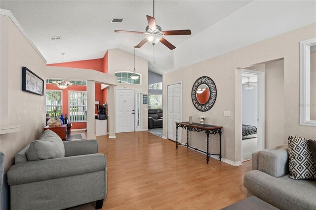 living room with light hardwood / wood-style flooring, high vaulted ceiling, and ceiling fan