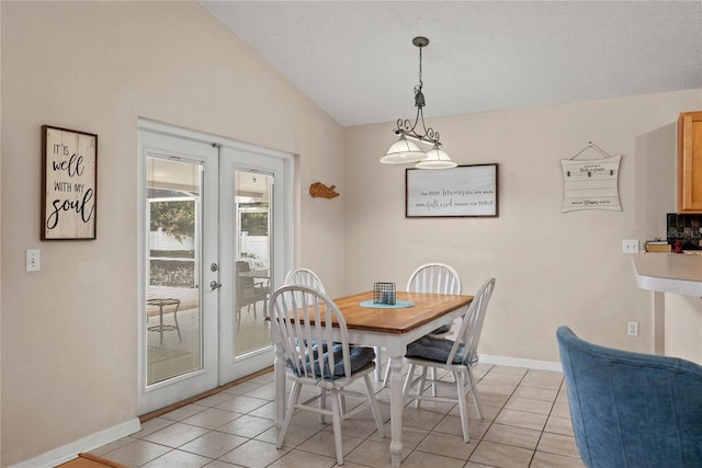 dining space with french doors, vaulted ceiling, and light tile patterned floors