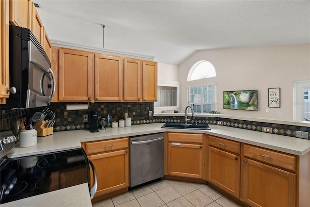 kitchen with lofted ceiling, sink, light tile patterned floors, appliances with stainless steel finishes, and tasteful backsplash