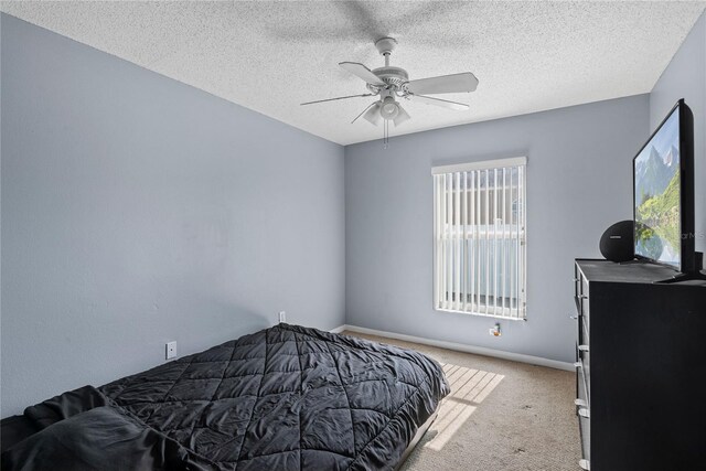 carpeted bedroom with ceiling fan, multiple windows, and a textured ceiling
