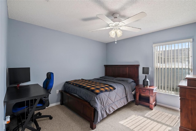 carpeted bedroom with ceiling fan and a textured ceiling