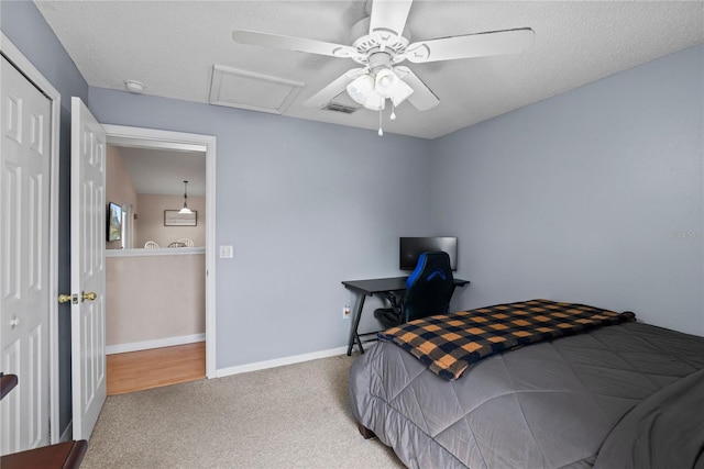 carpeted bedroom with ceiling fan and a textured ceiling