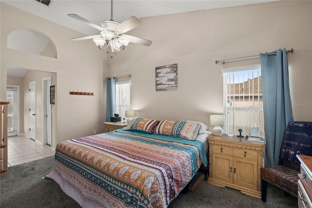 bedroom featuring ceiling fan, high vaulted ceiling, multiple windows, and light tile patterned floors
