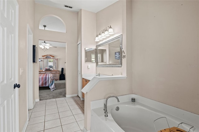 bathroom featuring vanity, a bathtub, a towering ceiling, ceiling fan, and tile patterned flooring