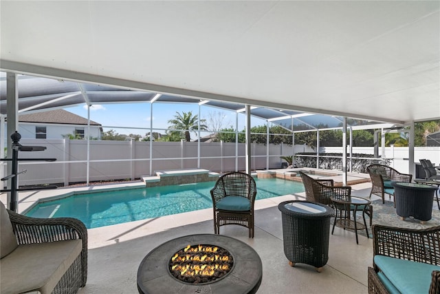 view of swimming pool featuring an in ground hot tub, a patio area, glass enclosure, and an outdoor fire pit