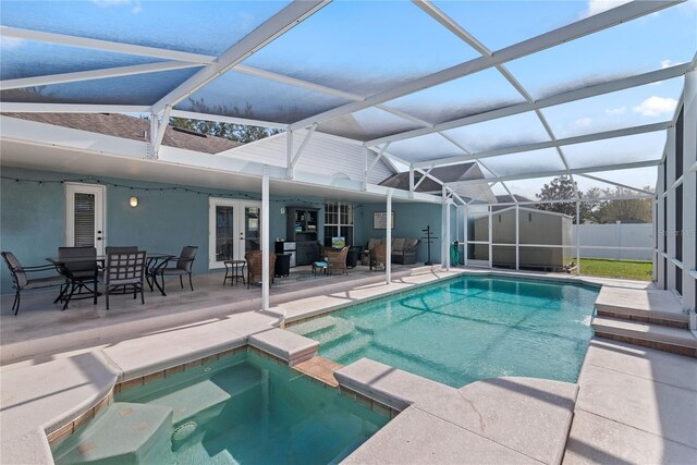 view of pool with an in ground hot tub, a patio, and glass enclosure