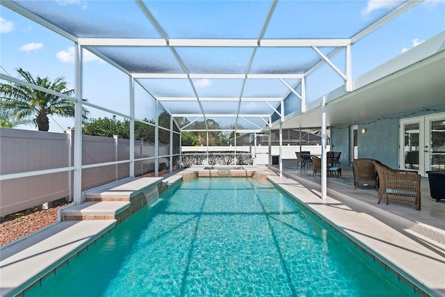 view of pool featuring pool water feature, a patio, and glass enclosure