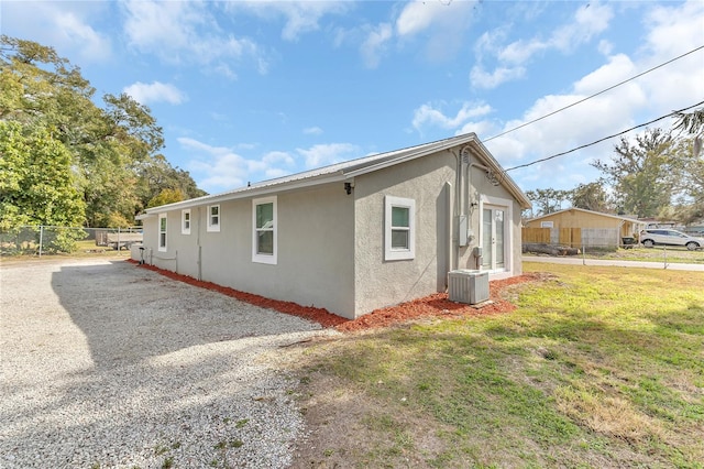 view of home's exterior with a yard and central AC