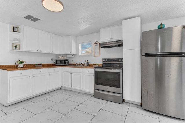 kitchen with stainless steel appliances, white cabinets, and a textured ceiling