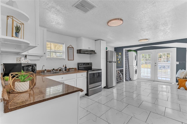 kitchen with sink, white cabinets, stacked washer and clothes dryer, kitchen peninsula, and stainless steel appliances