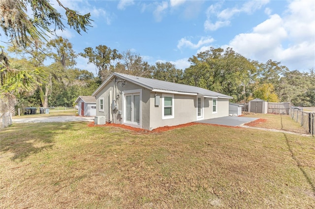 view of home's exterior featuring a patio, a storage shed, central AC unit, and a lawn