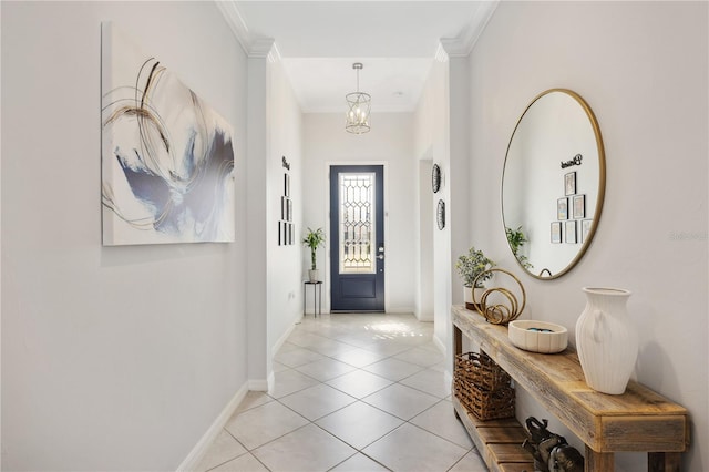 entrance foyer featuring an inviting chandelier, ornamental molding, and light tile patterned flooring