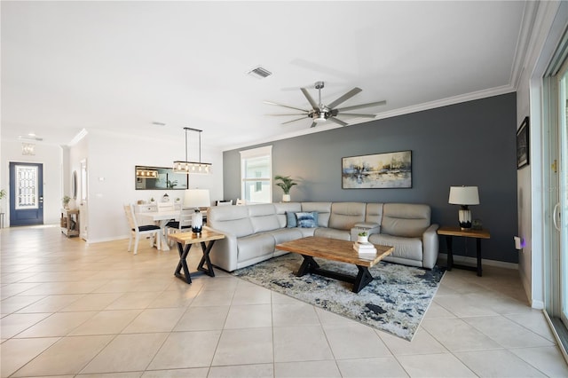 tiled living room with ornamental molding and ceiling fan with notable chandelier