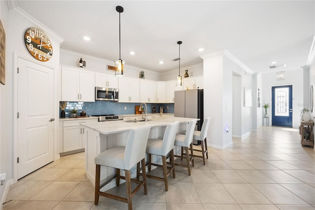 kitchen featuring sink, light tile patterned floors, a kitchen island with sink, tasteful backsplash, and white cabinets