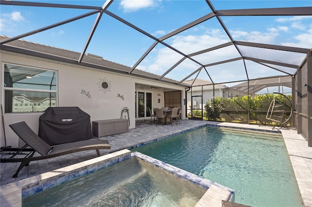 view of pool with ceiling fan, a grill, a lanai, and a patio area