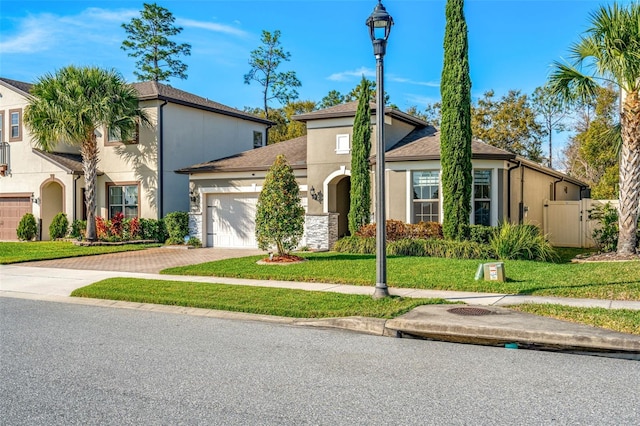 mediterranean / spanish home featuring a garage and a front lawn