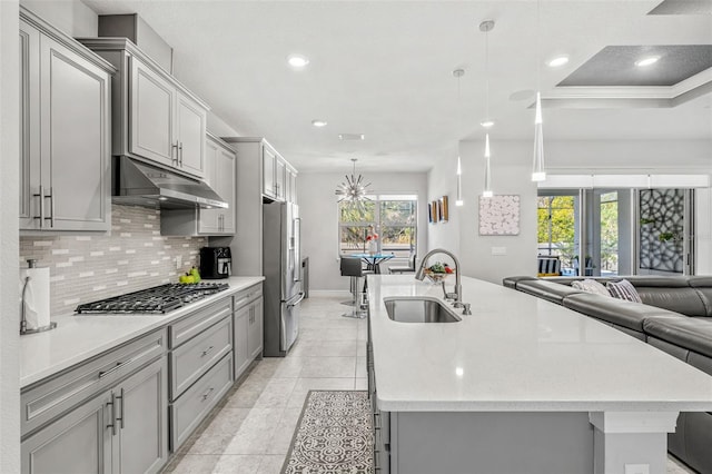 kitchen featuring gray cabinets, pendant lighting, sink, backsplash, and stainless steel appliances