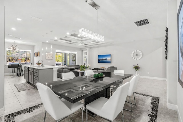 tiled dining room with coffered ceiling, sink, and an inviting chandelier