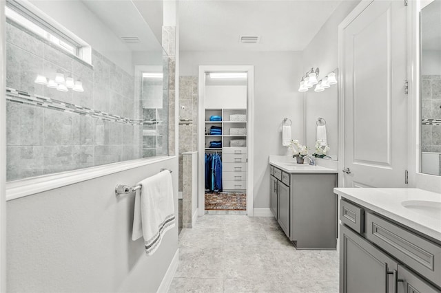 bathroom with vanity and a tile shower