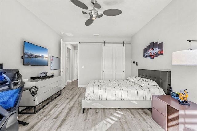 bedroom featuring a barn door and light wood-type flooring