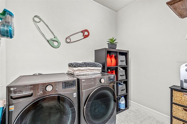 laundry room featuring washer and dryer and light tile patterned floors