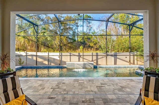 view of swimming pool with a patio, pool water feature, and glass enclosure