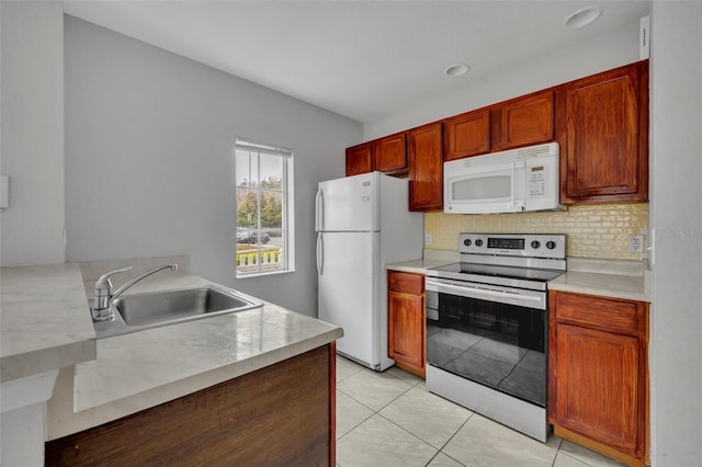 kitchen featuring tasteful backsplash, sink, white appliances, and light tile patterned floors