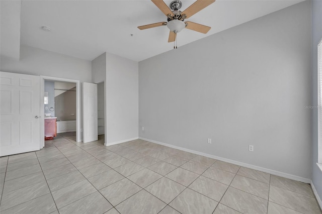 unfurnished bedroom featuring ensuite bathroom, light tile patterned floors, and ceiling fan